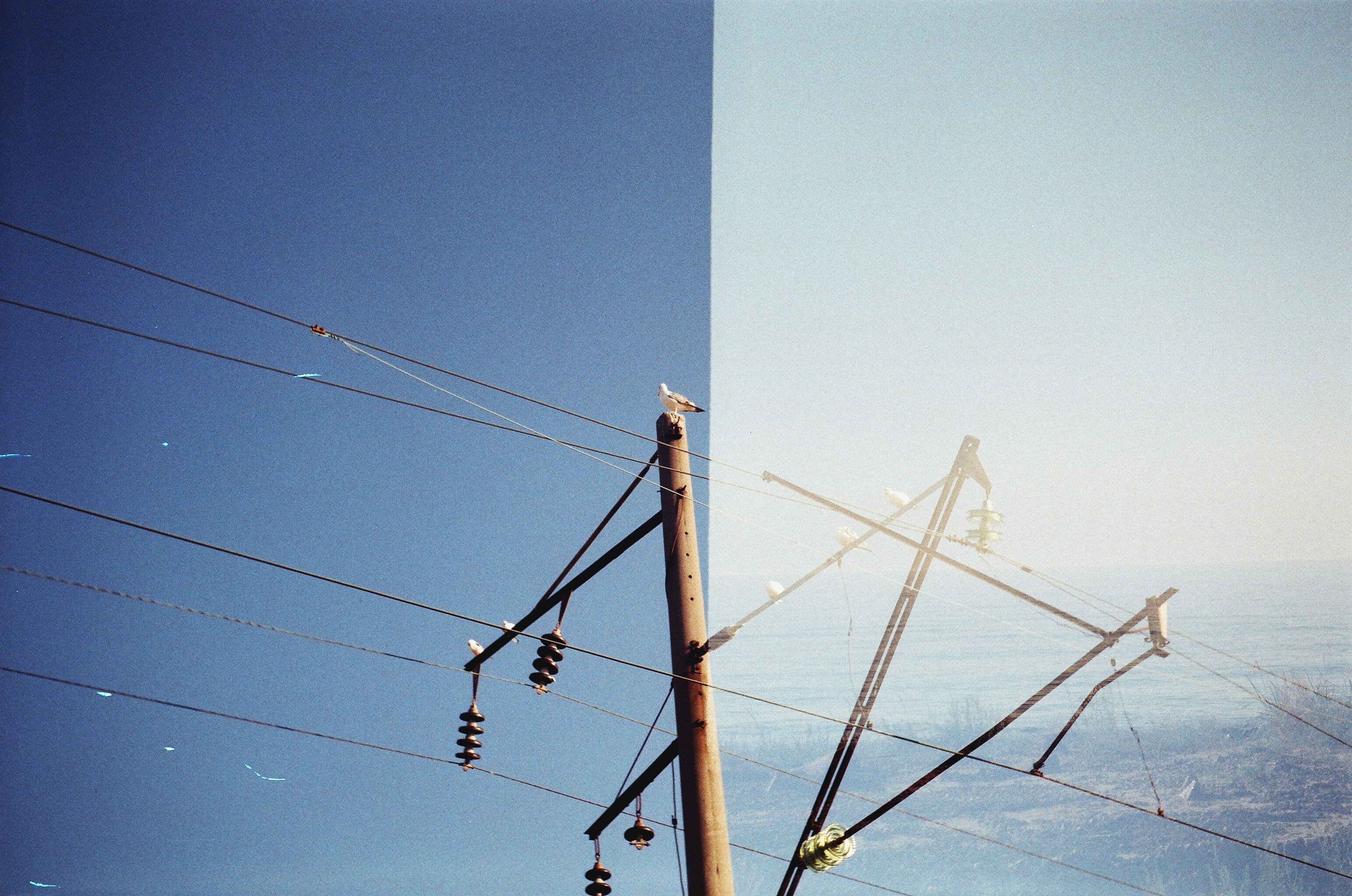 white electric post under blue sky during daytime